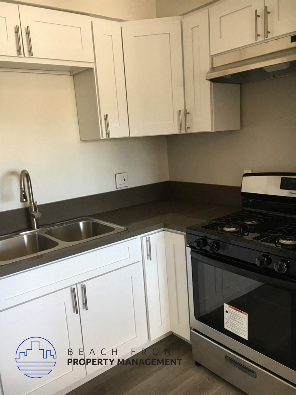 a kitchen with white cabinets and a sink and a stove