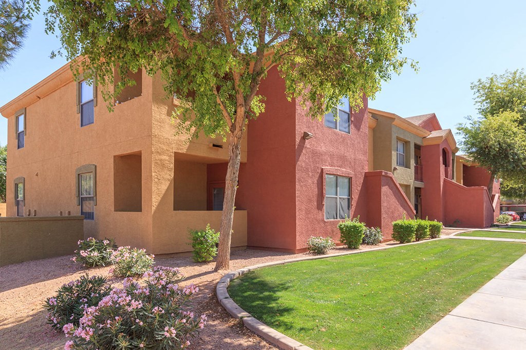 a building with a lawn and a tree in front of it