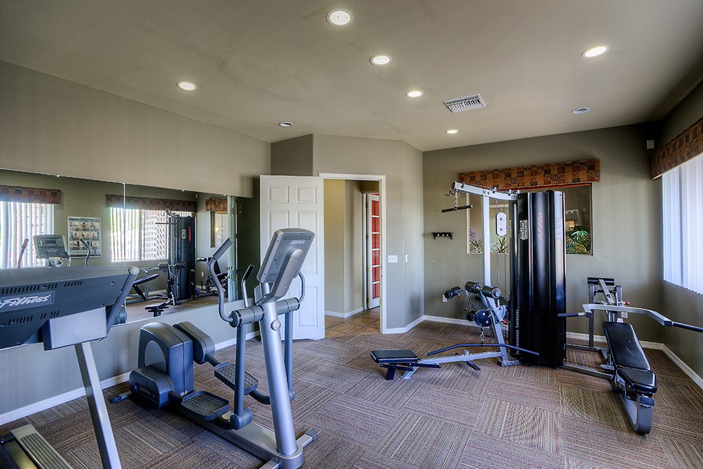 a gym with weights and cardio equipment at the enclave at university crossings apartments