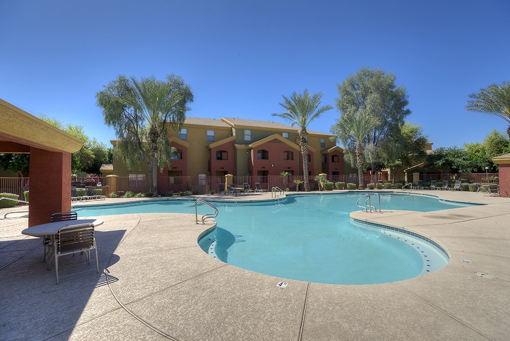 a resort style pool with a building in the background
