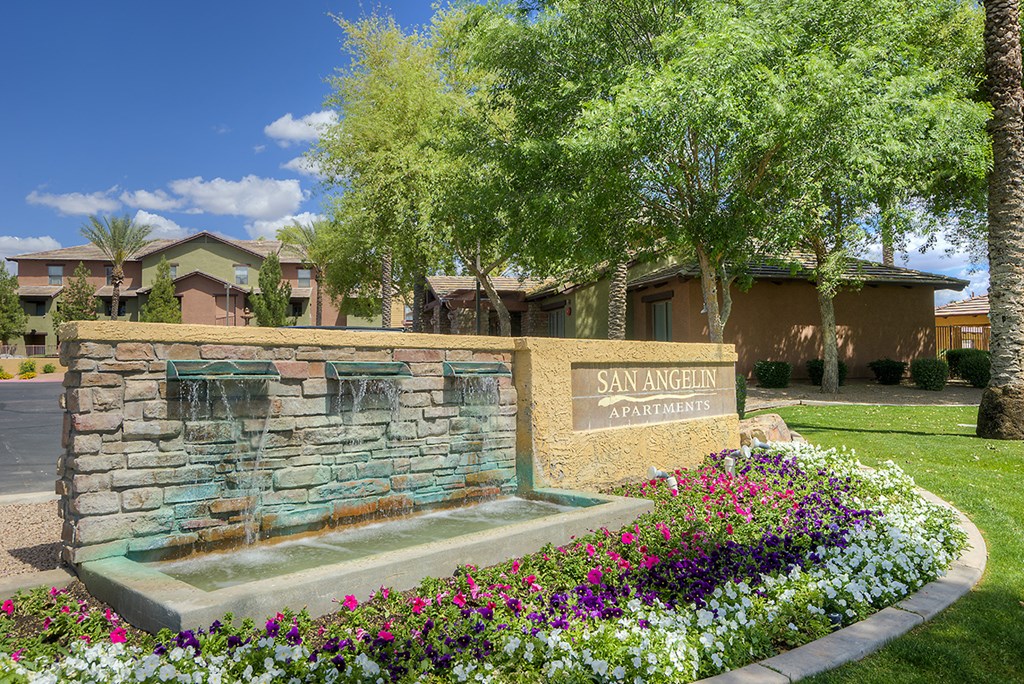 a fountain in front of a building with a sign