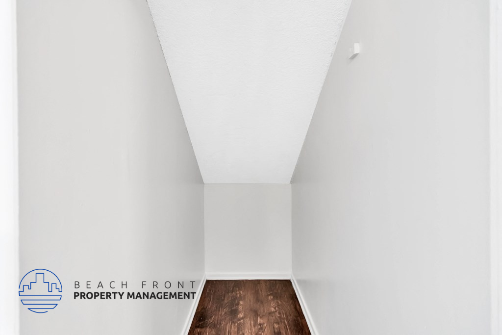 an empty room with white walls and a wooden floor