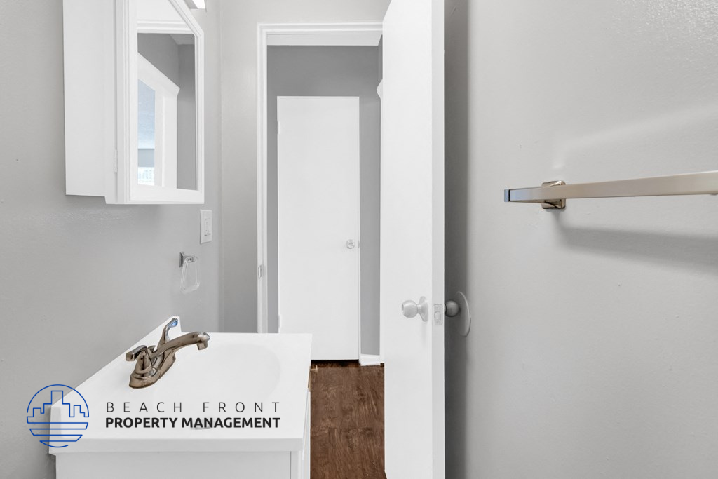 a bathroom with a sink and a mirror and a door
