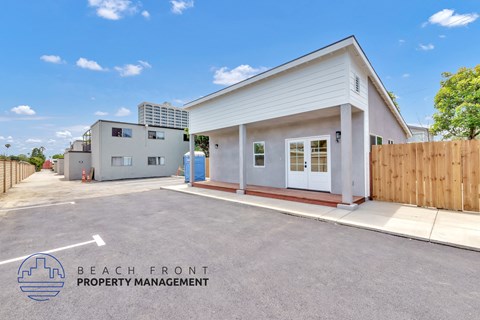 A white building with a sign that says Beach Front Property Management.