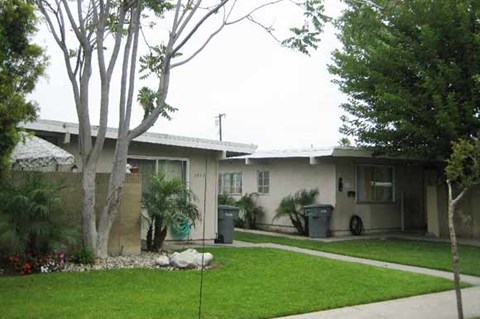 a house with a lawn and trees in front of it