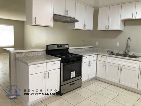 A kitchen with white cabinets and a black stove top oven.