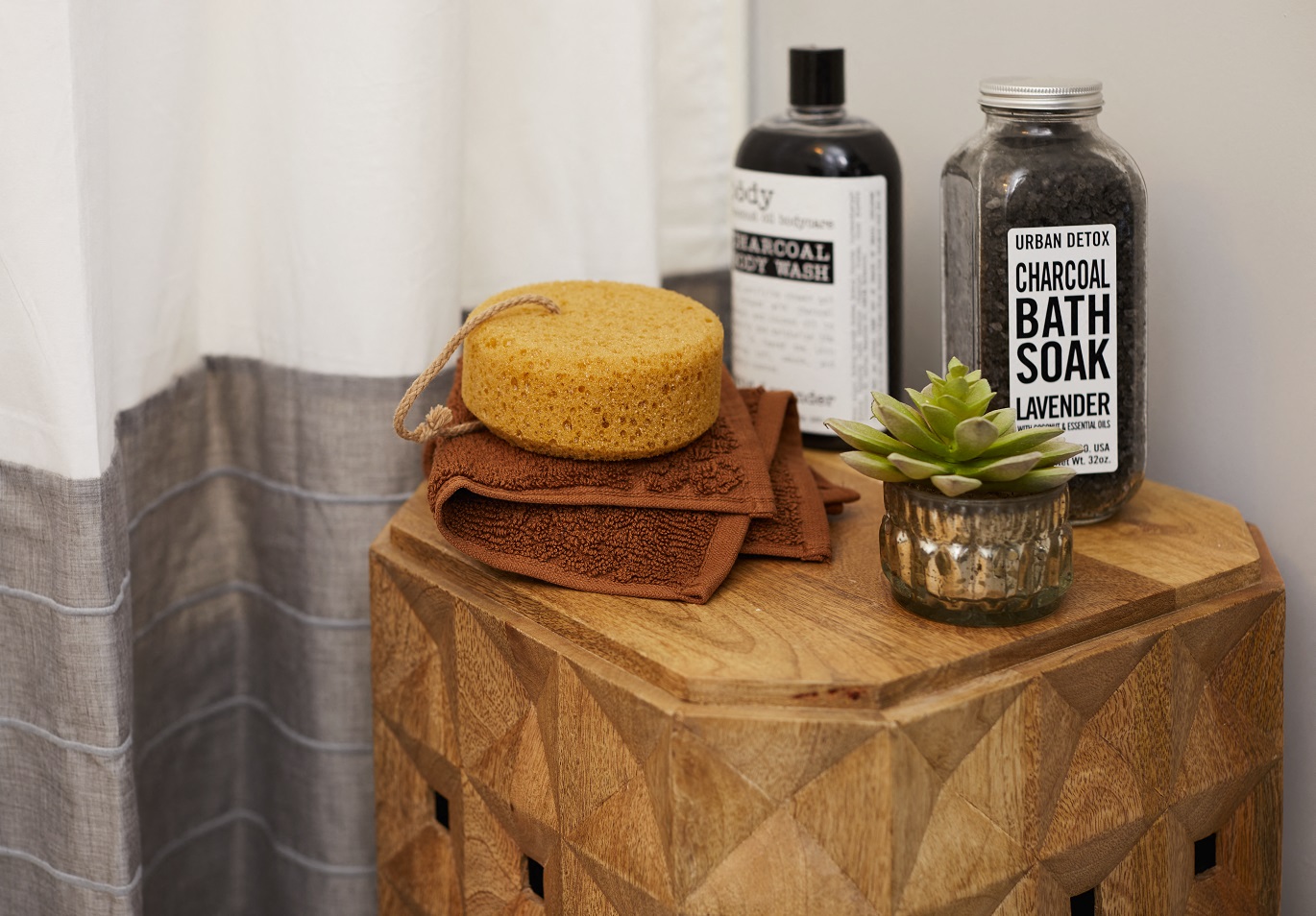 a wooden table topped with a cake and a bottle of bath salts