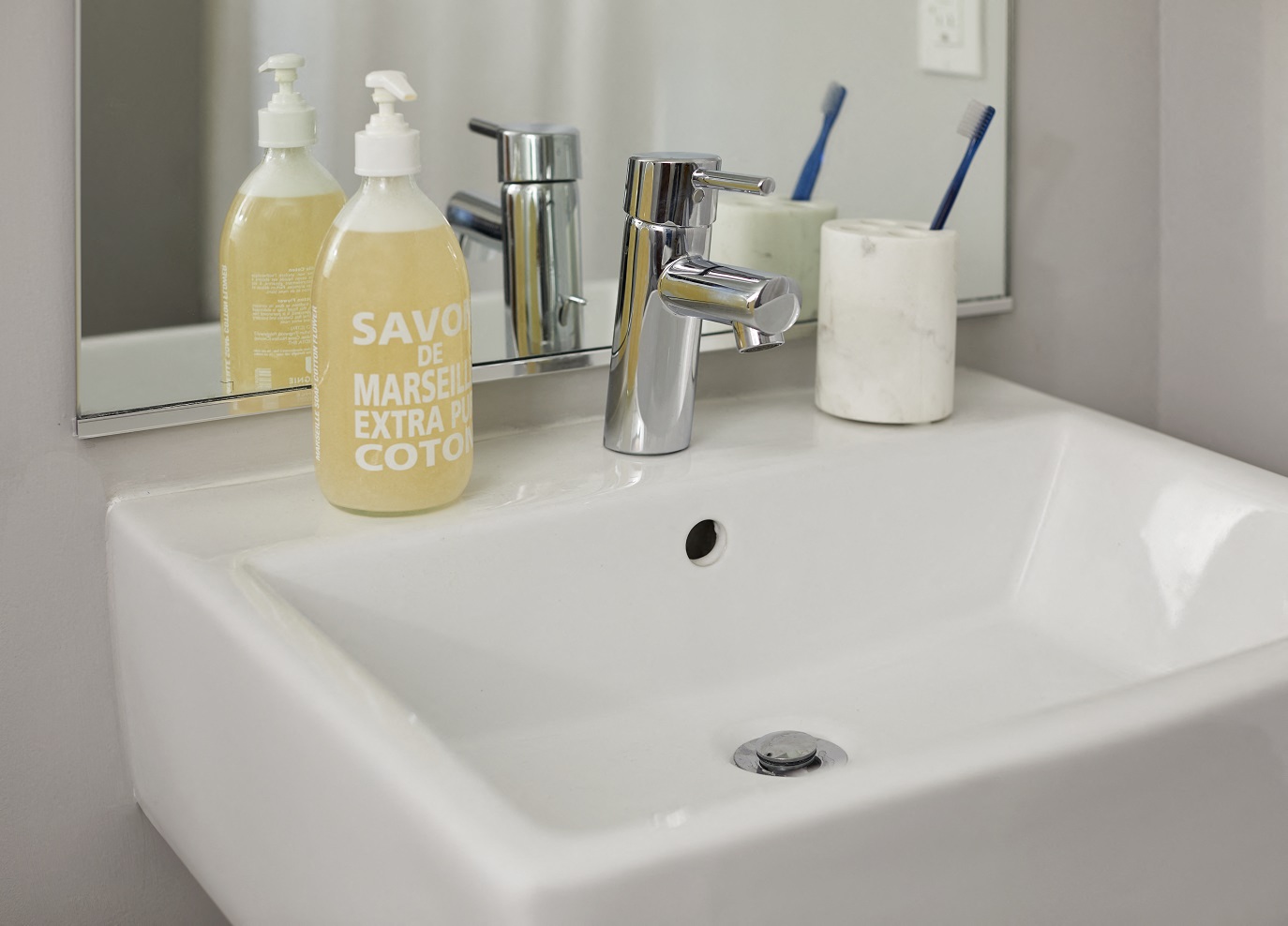 a bathroom sink with a bottle of soap on it