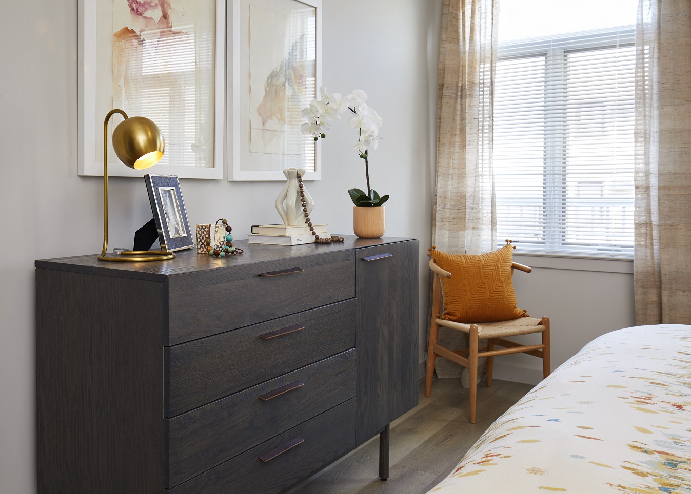 a bedroom with a dresser and a chair and a window