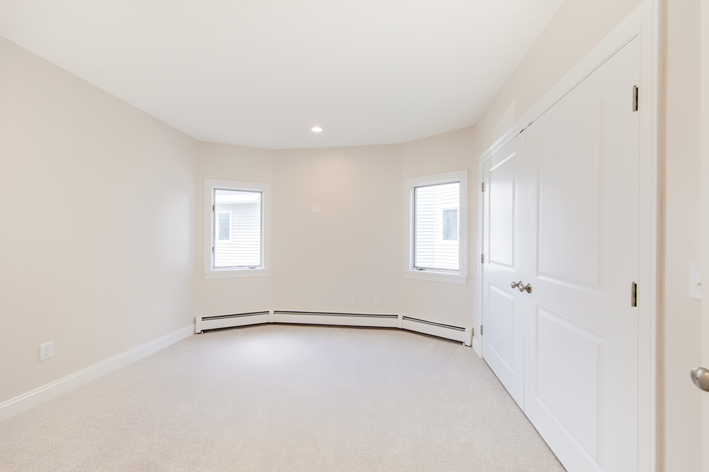 an empty room with white walls and a white door and window