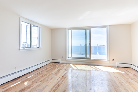 an empty living room with glass doors and a view of the ocean