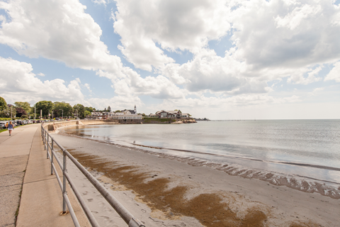 a view of the beach and the water from the promenade at the beach