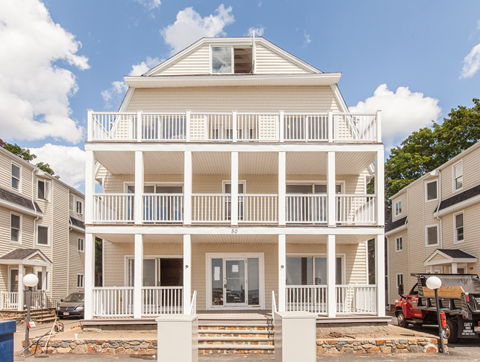 a white house with a porch on a sunny day