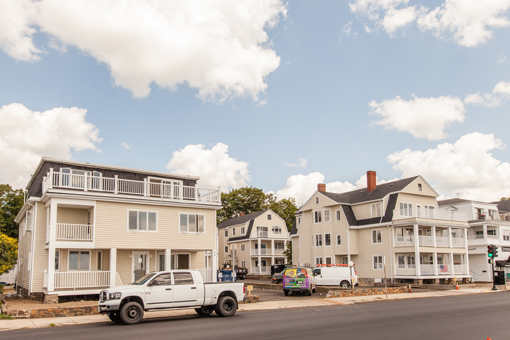 a white truck parked in front of houses on a street