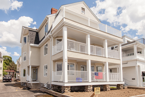 a white house with an flag on the porch