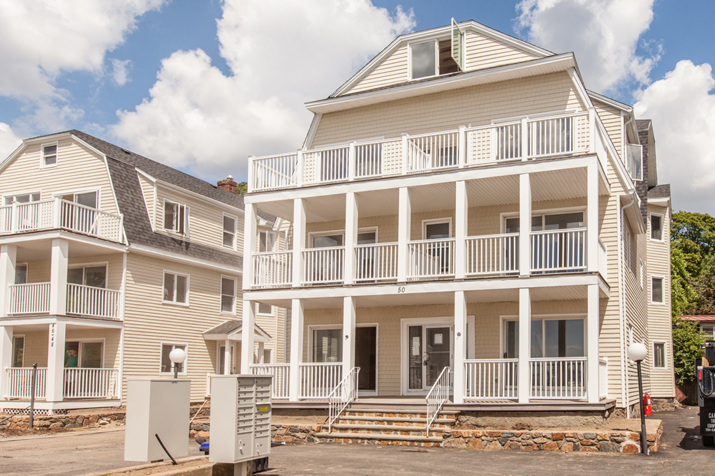 two white houses with balconies on a cloudy day