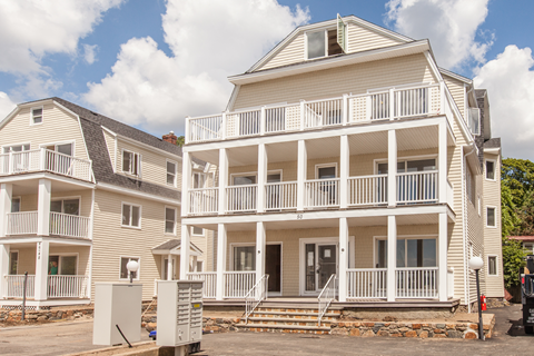 two white houses with balconies on a cloudy day