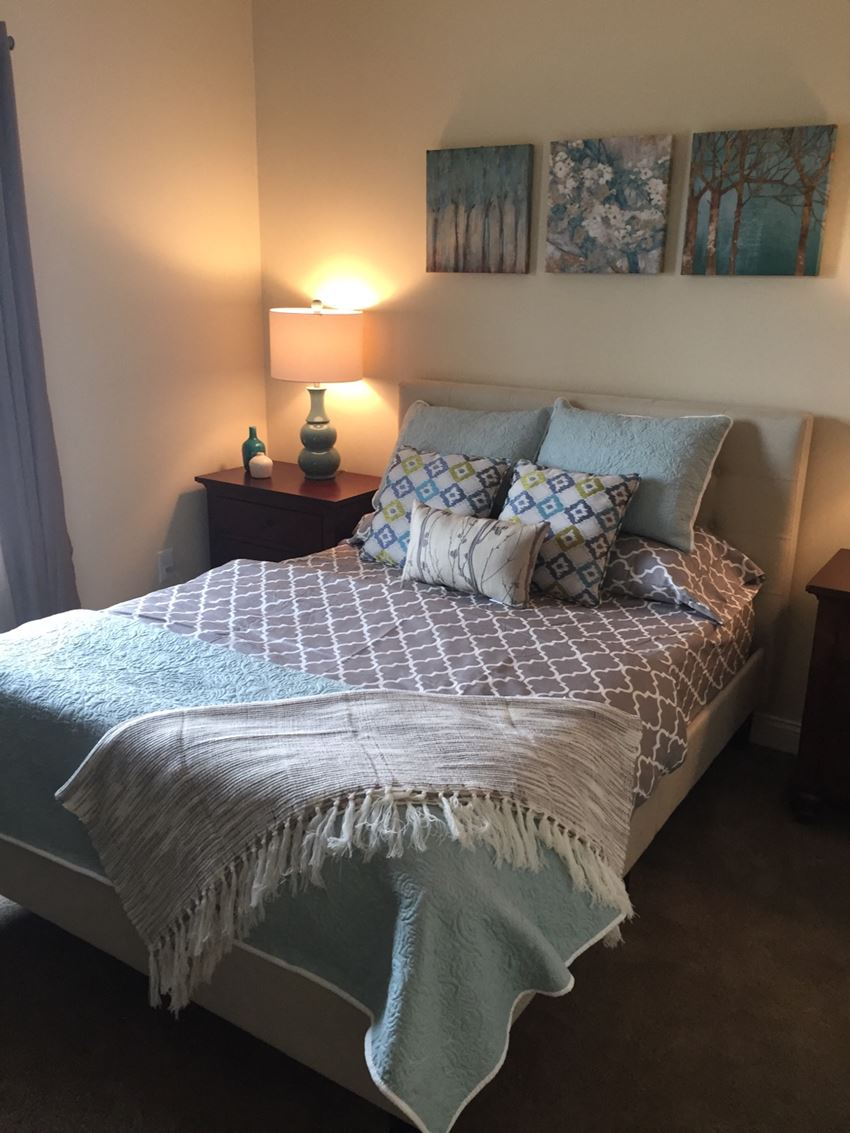 a bedroom with a bed and several pillows on it