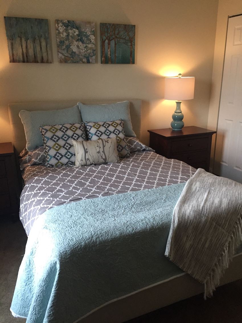 a bedroom with a bed with pillows and a blue blanket