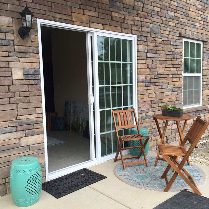 a patio with two chairs and a sliding glass door