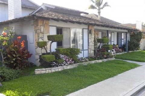 a house with a lawn and a sidewalk in front of it