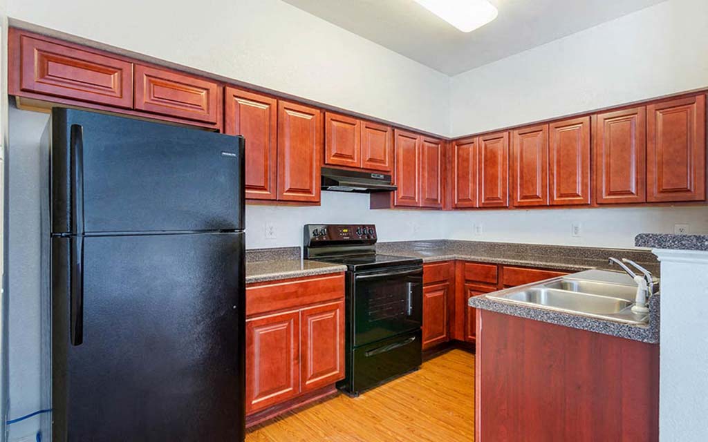 a kitchen with black appliances and wooden cabinets