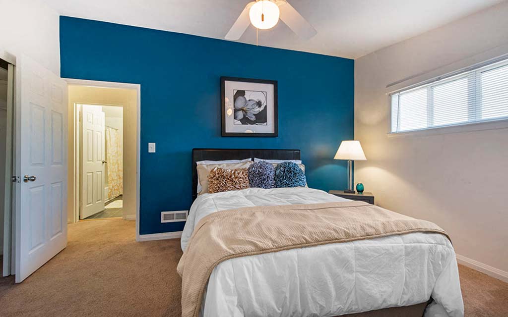 a bedroom with a bed and a blue wall