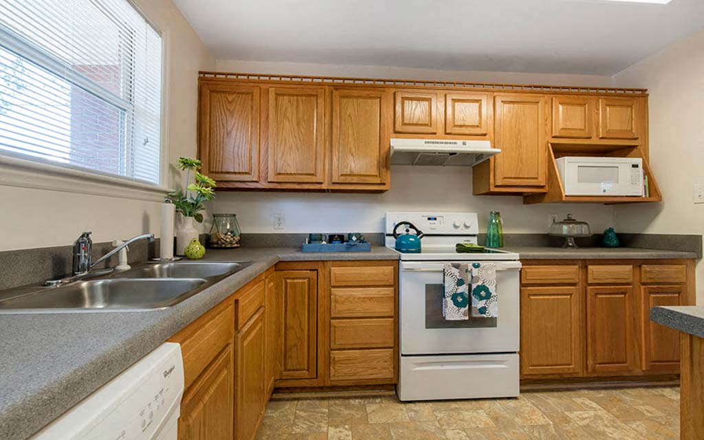 a kitchen with wooden cabinets and white appliances