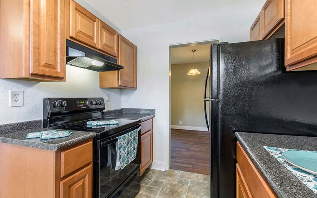a kitchen with black appliances and wood cabinets