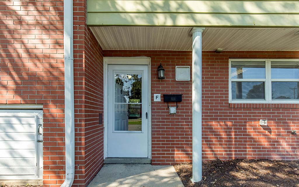 a brick house with a white door and a porch