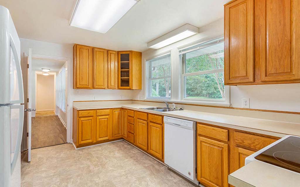 an empty kitchen with wooden cabinets and a sink