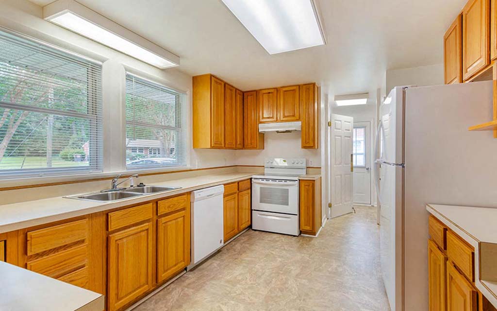 a kitchen with wooden cabinets and a sink and a refrigerator