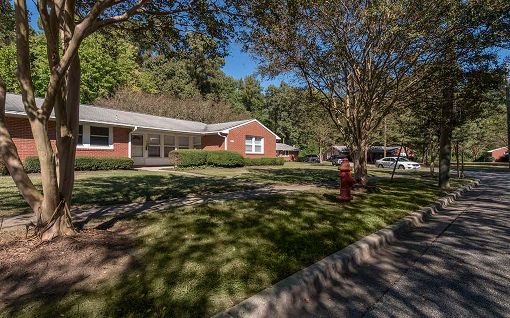 a red house with a red fire hydrant in the grass