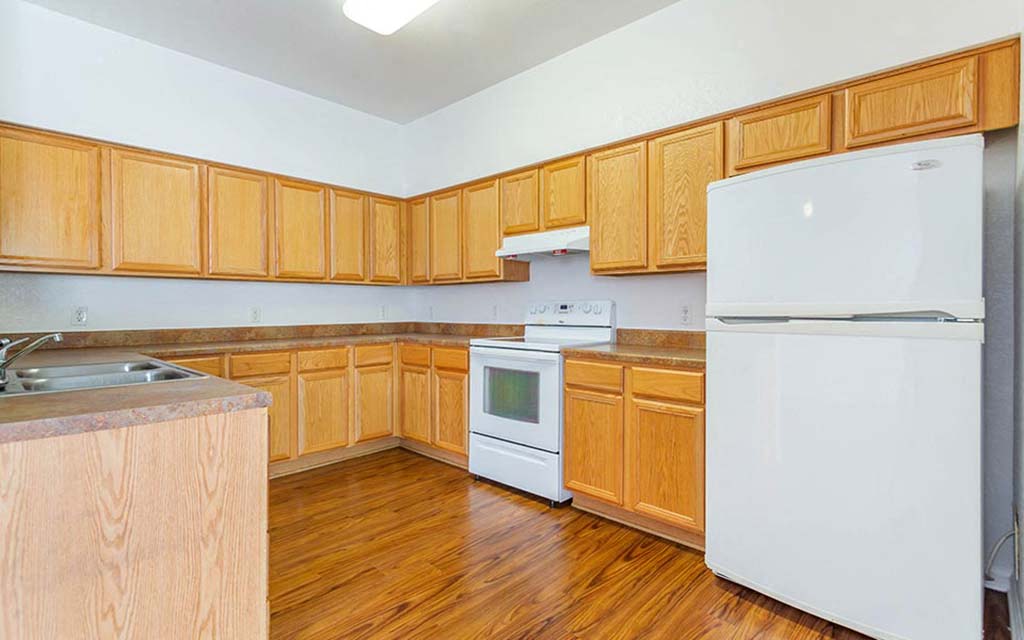 a kitchen with wooden cabinets and white appliances