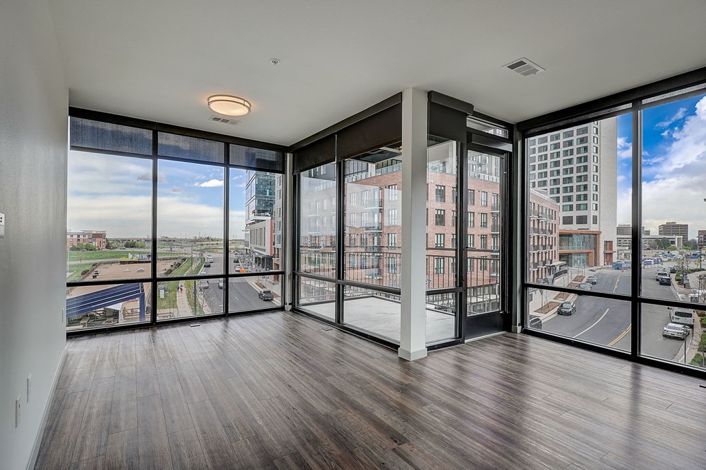 a living room with floor to ceiling windows and a view of the city