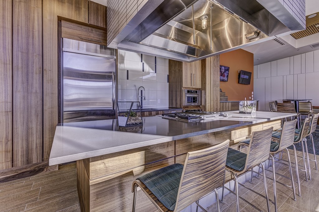 a kitchen with stainless steel appliances and a large island with chairs