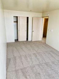 an empty living room with white walls and a tile floor