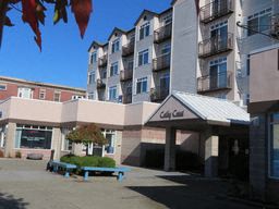 an apartment building with a blue bench in front of it