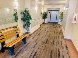 a hallway with benches and plants in a building