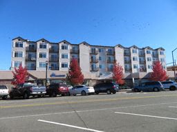 an apartment building with cars parked in front of it