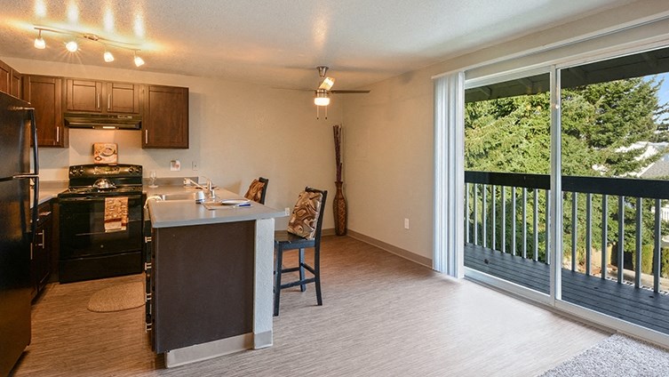 a kitchen with a large sliding glass door to a balcony