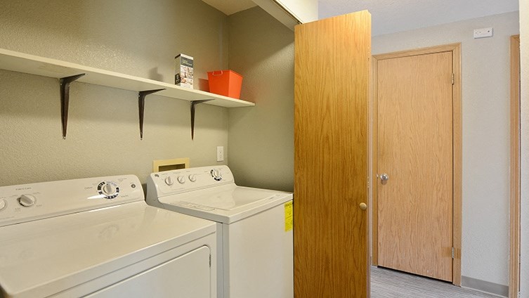 a laundry room with a washer and dryer next to a door