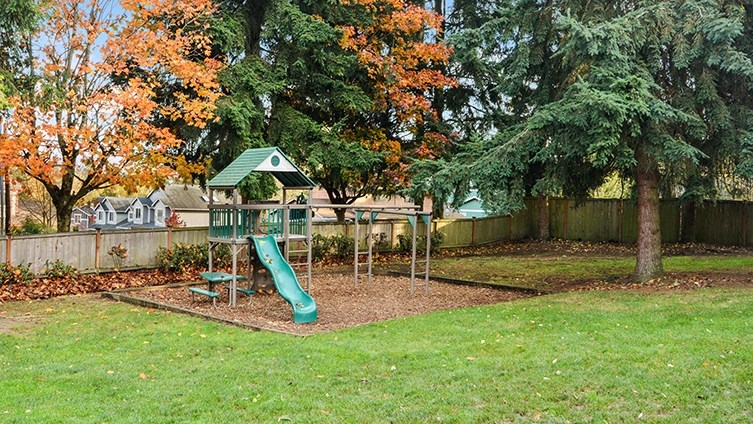a playground with a swing set in a park