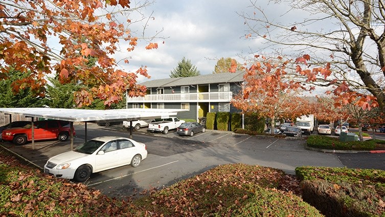 a parking lot with cars in front of a motel