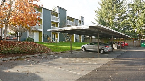 a parking lot with cars in front of an apartment building