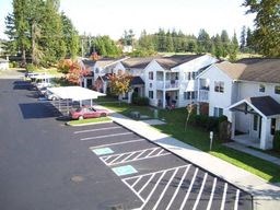an aerial view of a parking lot and a row of houses