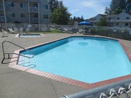 a large swimming pool in front of an apartment building