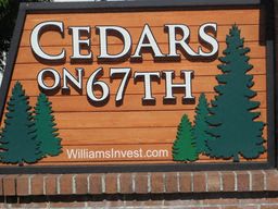 a sign for cedars on 67 with trees on it