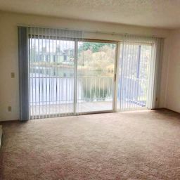 an empty living room with sliding glass doors to a balcony