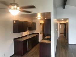 an empty kitchen with a ceiling fan and a long